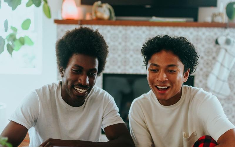 father and son sit together in living room